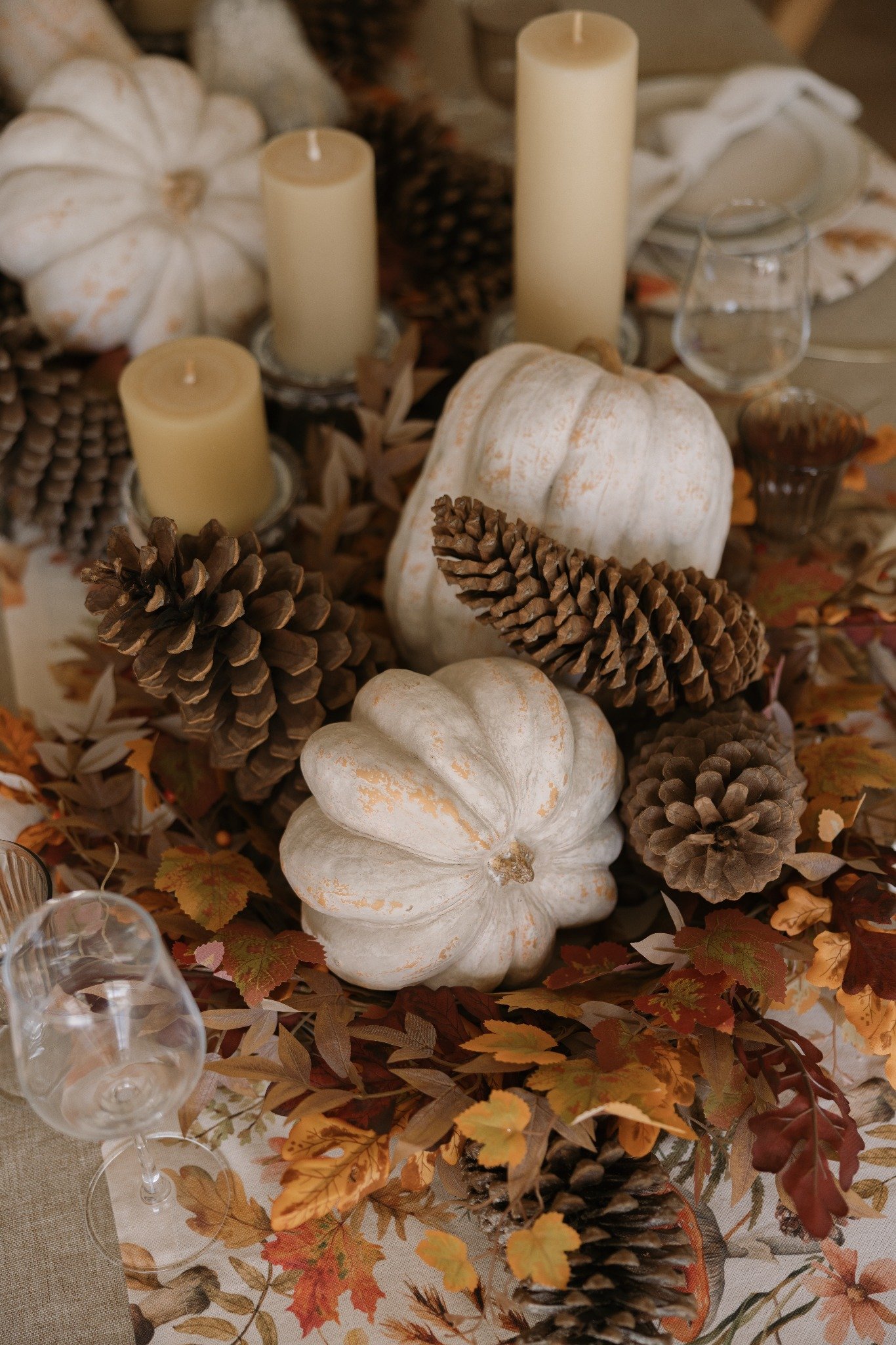 Detalle de mesa otoñal DEKOR con calabazas blancas, piñas y velas